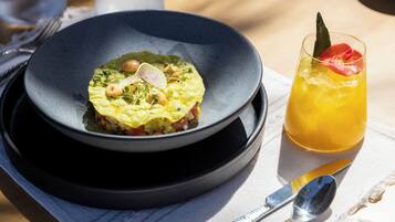 Une assiette de nourriture et un verre de boisson sur une table.