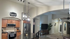 Una cocina moderna con armarios de madera, electrodomésticos de acero inoxidable y una isla central.