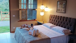 Un dormitorio con cama, mesita de noche y ventana con contraventanas.