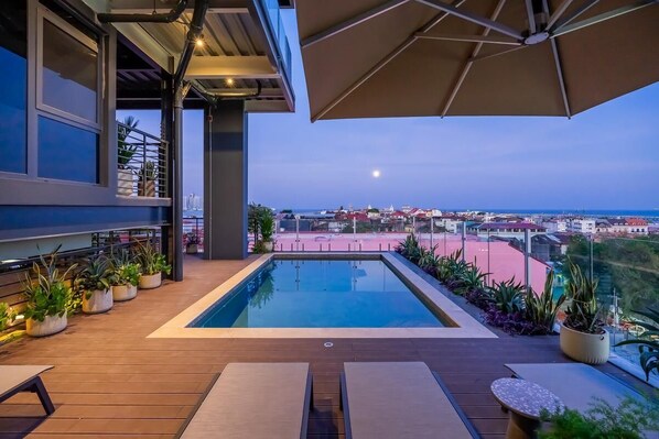 Una piscina al aire libre con vistas a la ciudad y al mar.