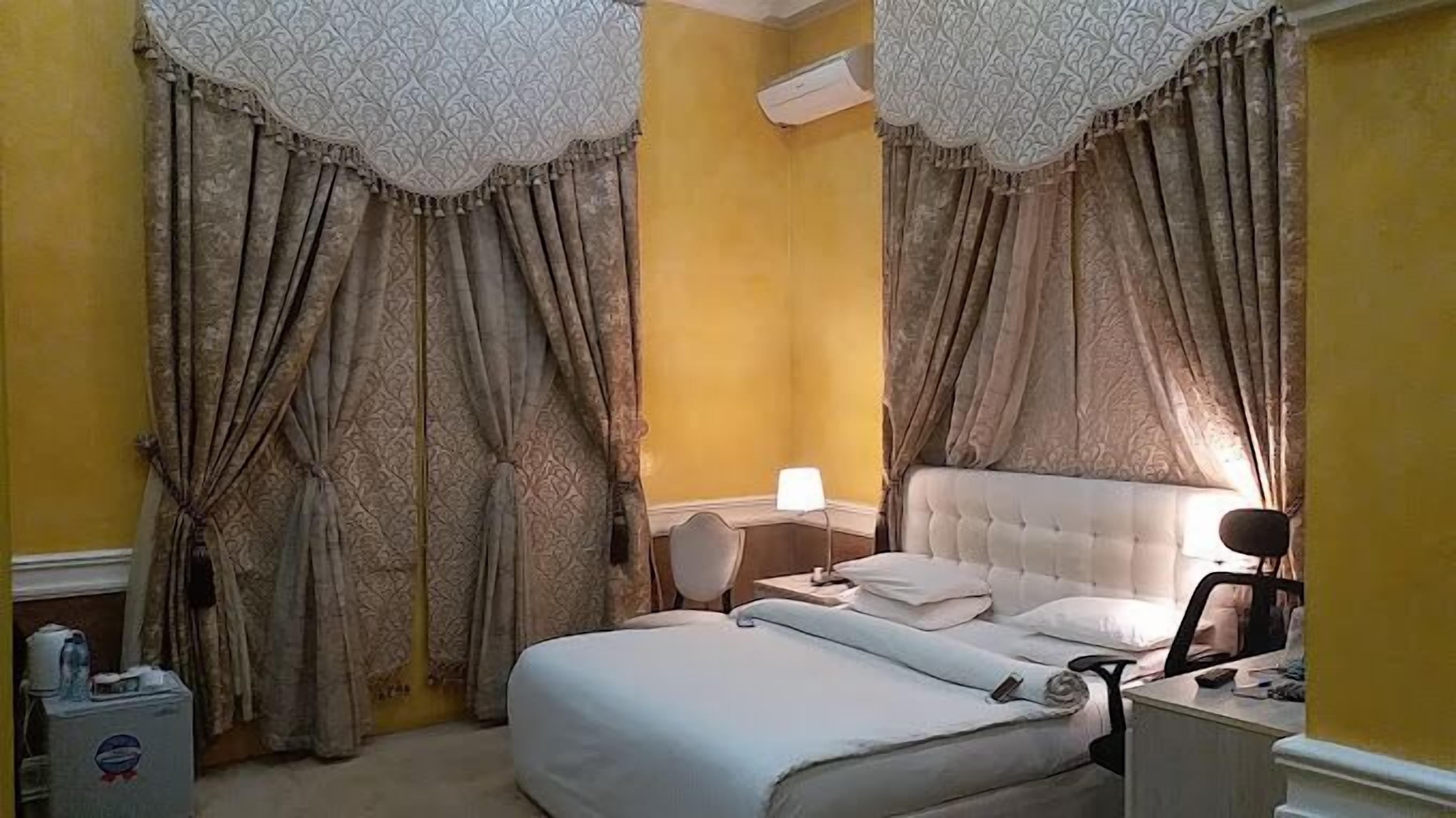 Een slaapkamer met een bed, een bureau en een airconditioning.