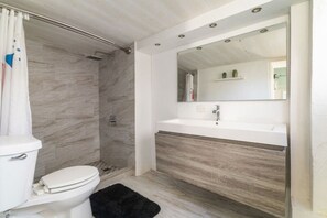 A modern bathroom with a shower, toilet, and vanity.