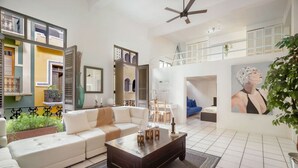 A spacious living room with a white sofa, a coffee table, and a ceiling fan.
