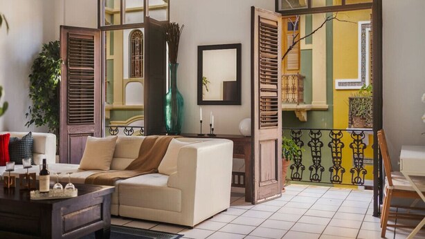 A living room with a sofa, a coffee table, and a potted plant.