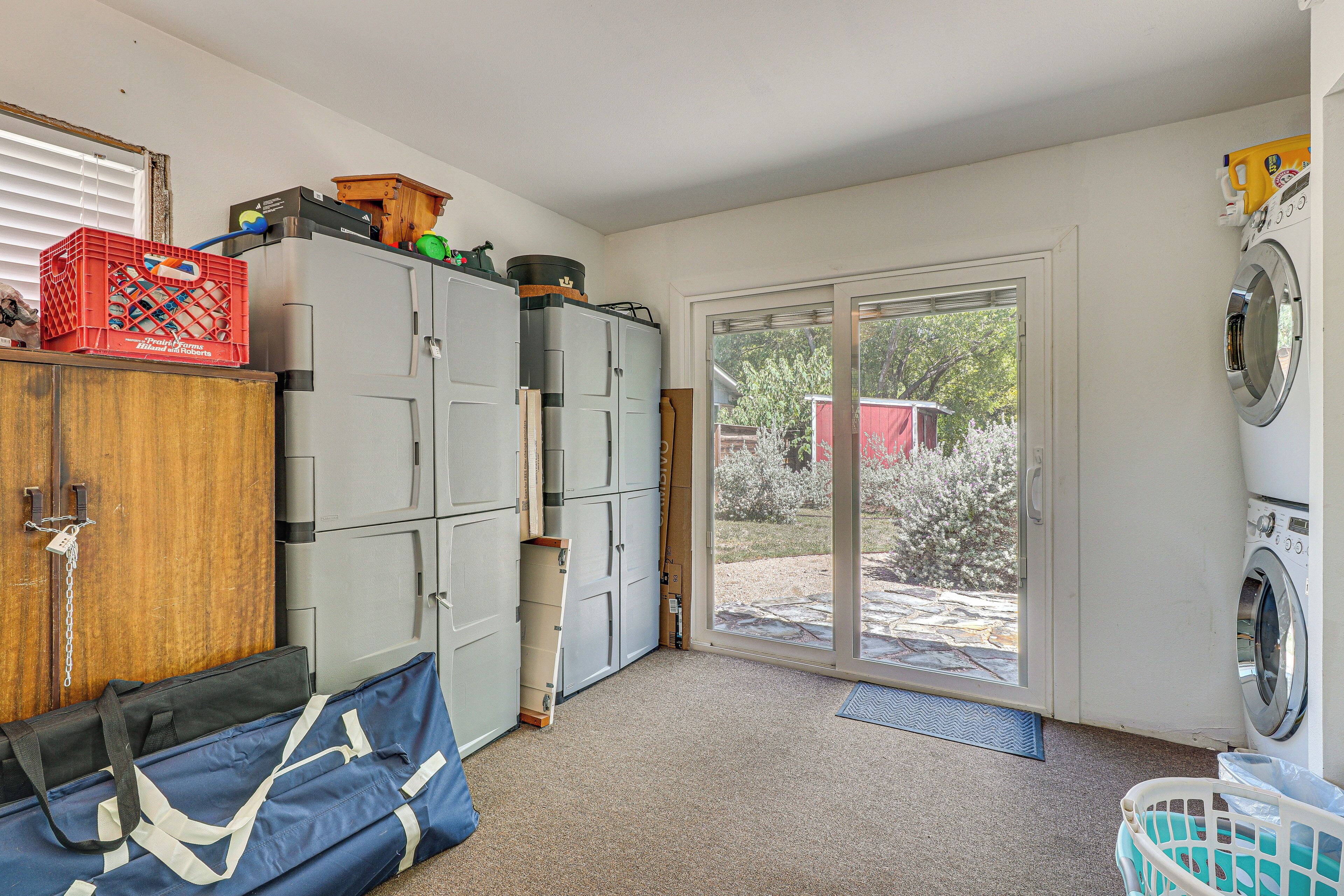 A laundry room with a washing machine, a dryer, and a large window.
