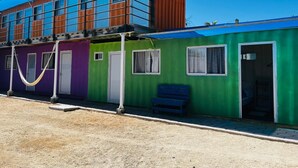 Un bâtiment aux couleurs vives, doté de nombreuses pièces, d’un hamac et d’un banc.