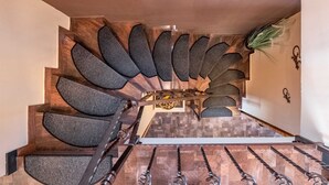 A spiral staircase with a modern design, leading to a landing area with a small table and decorative items. - Villa Badi with private pool (Malinska (Krk))