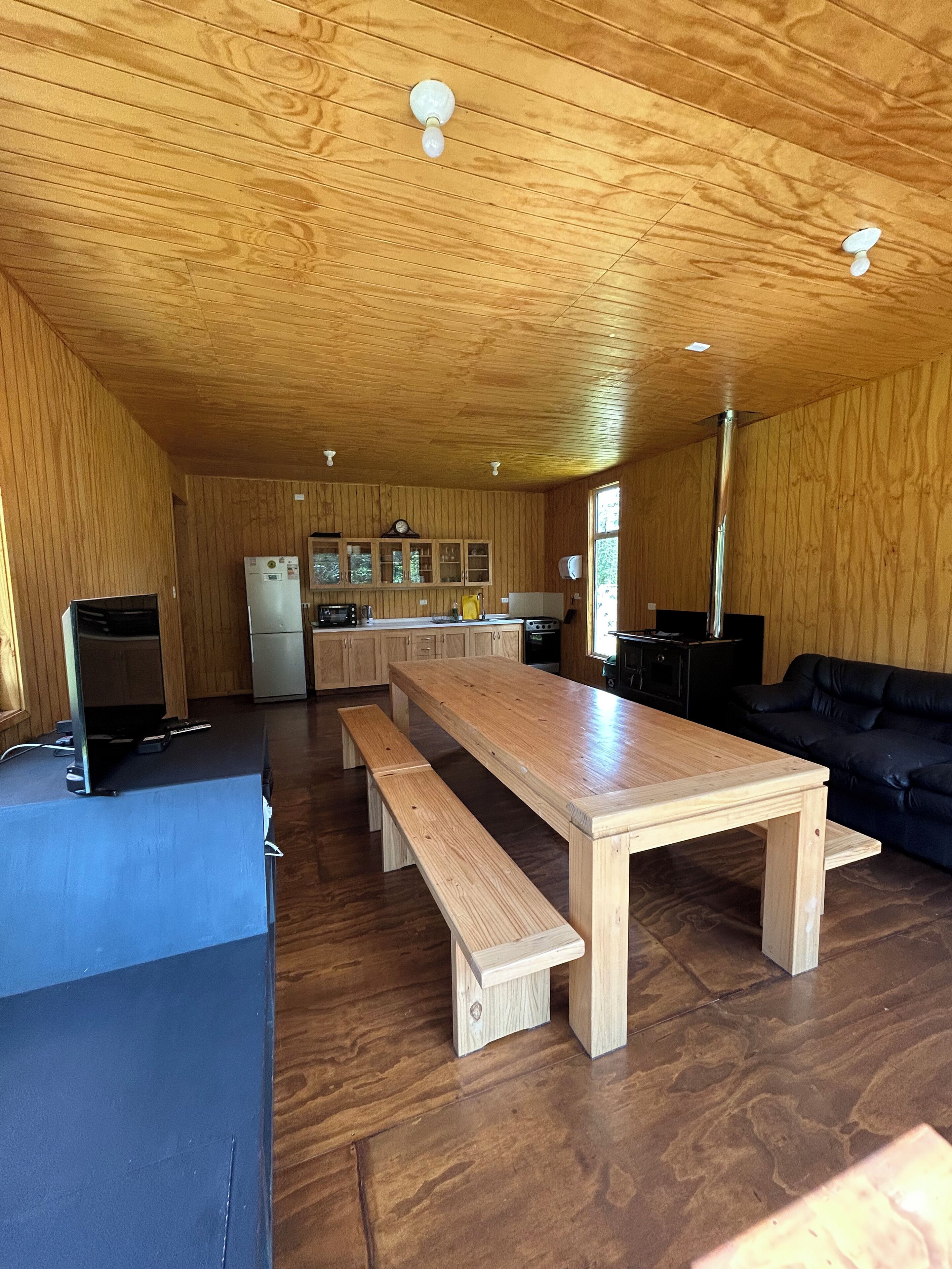 A spacious kitchen with wooden cabinets, a central island, and a dining area with a bench.