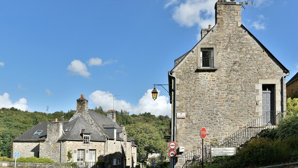 A stone building with a traditional design, a visible staircase, and a stop sign.