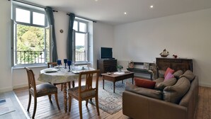 A living room with a dining area, a television, and a sofa.