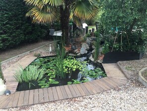 Surround yourself with nature in our serene garden, featuring a peaceful pond and lush greenery.
