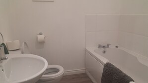 A bathroom with a toilet, sink, and bathtub. - Tranquil Retreat Close to the Coast (Coleraine)