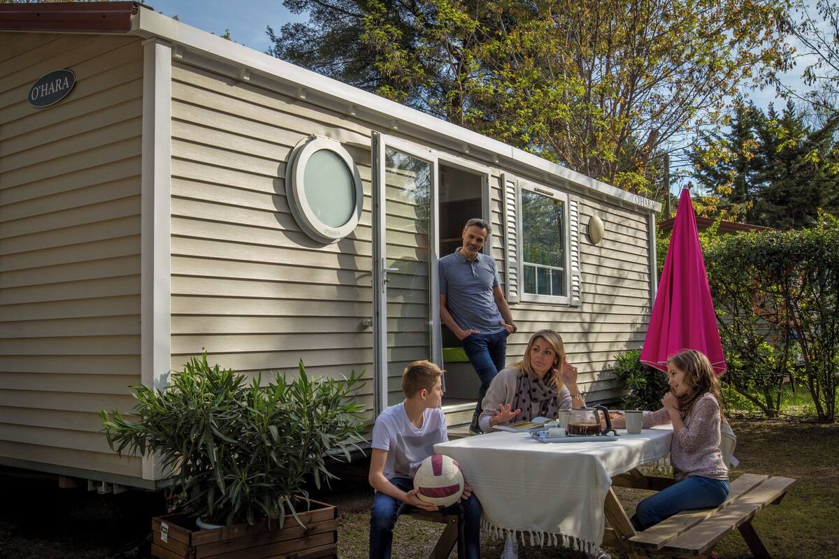 A mobile home with a dining area set up outside.