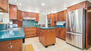 Une cuisine moderne avec des meubles en bois, des appareils électroménagers en acier inoxydable et un plan de travail bleu.