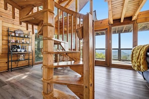 A wooden interior with a spiral staircase, a coffee station, and large windows offering a view. - Best Views in Sevierville! 1b/2ba + Loft! Hot Tub. 15 min to Pigeon Forge! (Sevierville)
