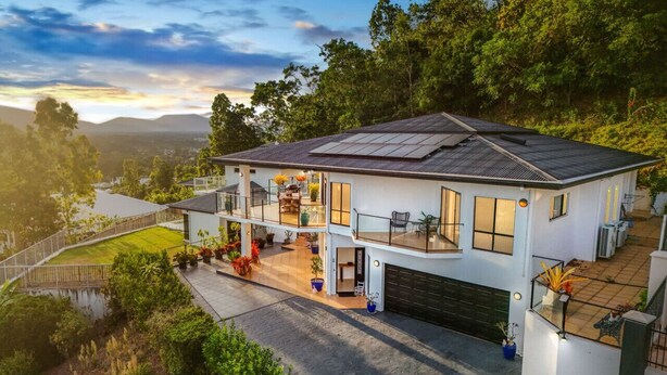 A two-story house with a flat roof, large windows, and a balcony. - Your Ultimate Escape in Mooroobool- Luxury Tropical Retreat with Pool & Stunning Views – Perfect for Families & Groups! (Mooroobool)