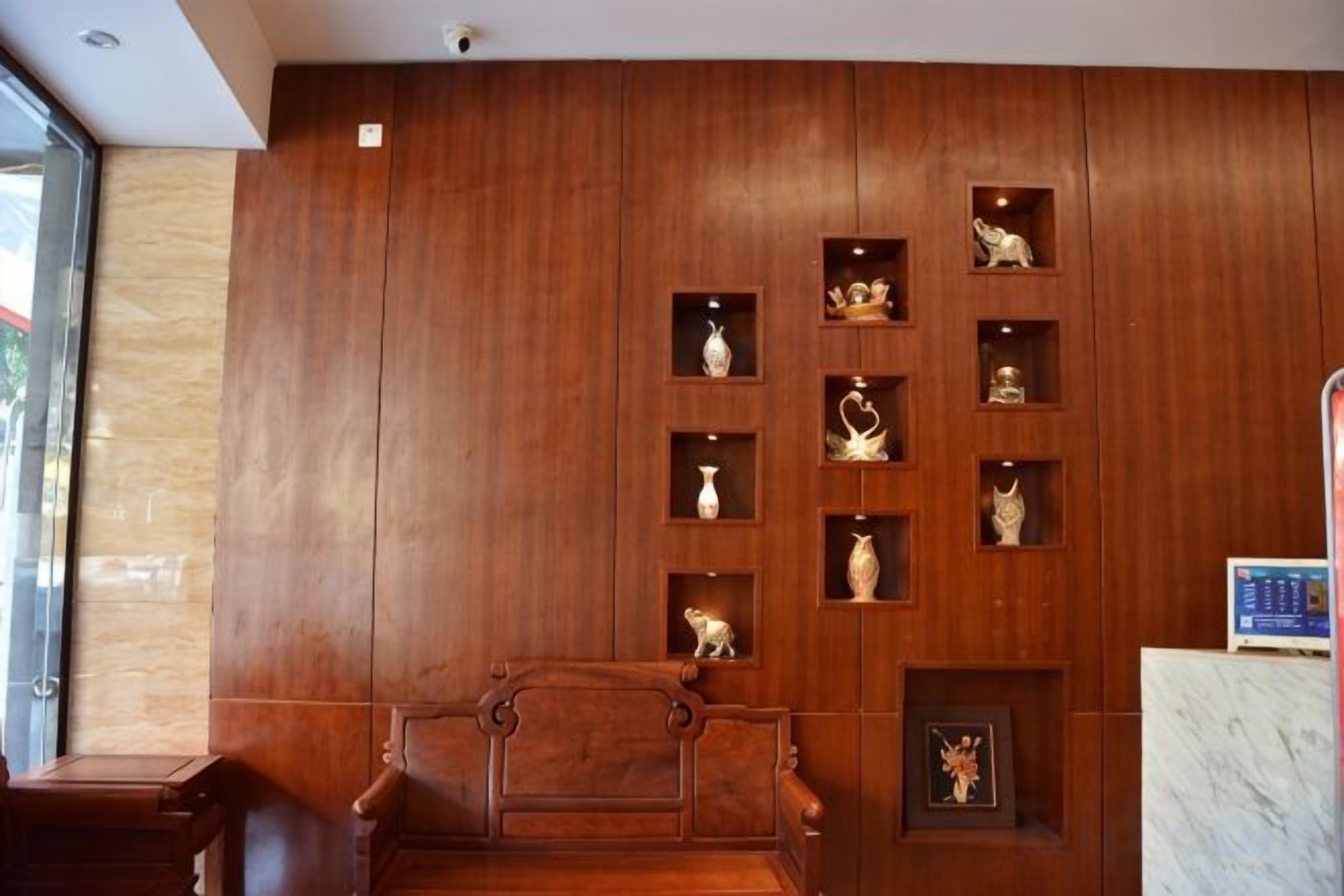 A wooden wall with shelves displaying various items, a wooden bench, and a marble counter.