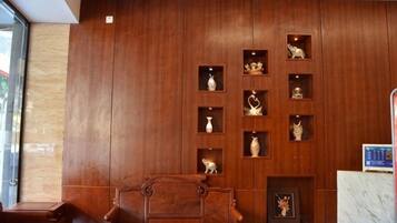 A wooden wall with shelves displaying various items, a wooden bench, and a marble counter.