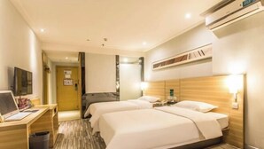 A hotel room with two beds, a desk with a laptop, a TV, and an air conditioning unit. - Mingdu Hotel (Ningming)