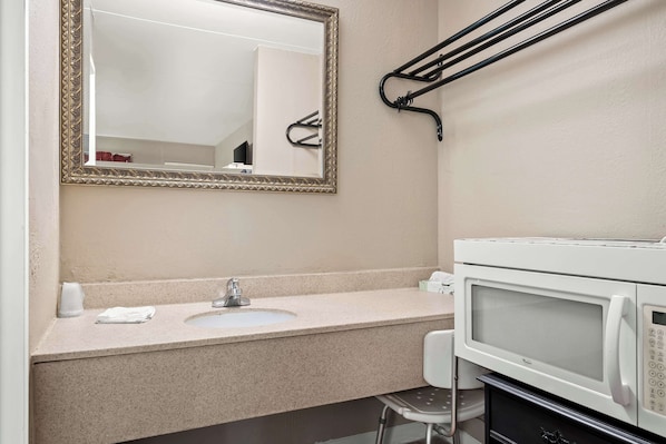 A bathroom with a sink, mirror, towel rack, and a microwave. - Americas Best Value Inn Danville (Danville)