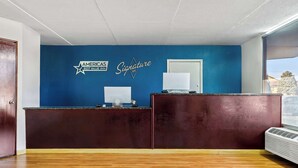 Een receptiebalie met een blauwe wand, een witte deur en een raam.
