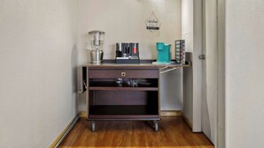 Een kleine kitchenette met een koffiezetapparaat, een waterkoker en een koffiemachine op een karretje.