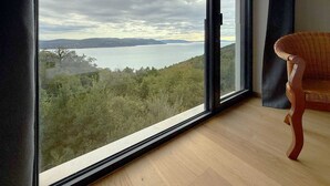 A room with a large window offering a view of a lake and hills. - Villa Ena in peaceful location with a sea view (Zagorje)