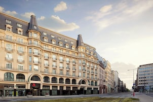 A multi-story hotel with a classic European architectural style, featuring arched windows and balconies.