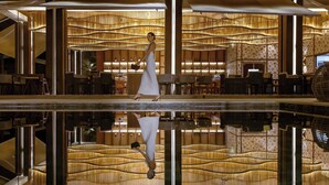 A spacious lobby with a central reflective pool, seating areas, and a decorative bamboo wall. - Donoma Las Terrenas Resort & Villas Autograph Collection (Las Terrenas)