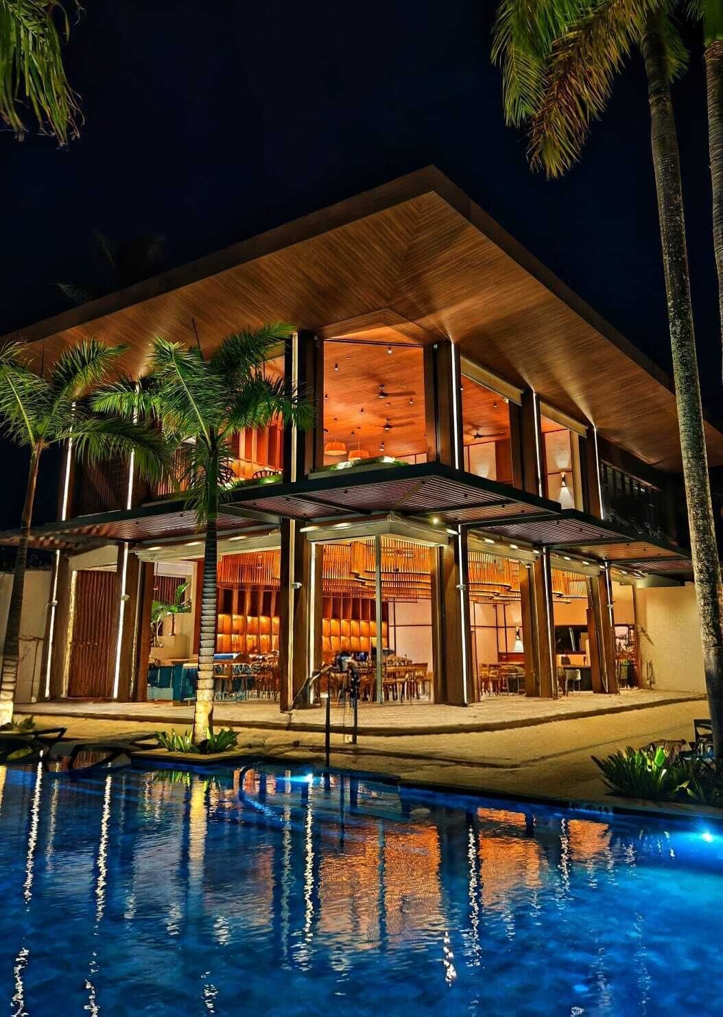 A modern two-story building with a pool in front.