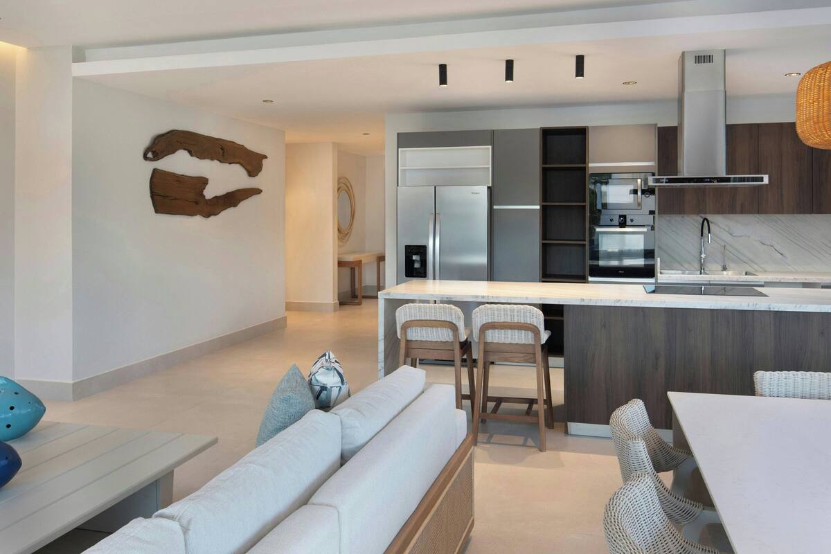 A modern kitchen with a central island, built-in oven, and stainless steel appliances.