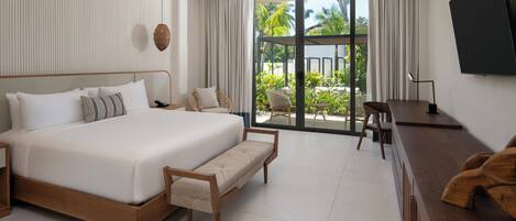 A modern hotel room with a large bed, a desk, and a TV.