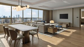 A modern living room with a dining area, large windows, a flat-screen TV, and a city view. - Shanghai Marriott Hotel Yangpu Riverside (Shanghai)