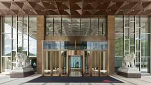 A hotel entrance with a geometric ceiling design, large glass windows, and two elephant statues. - Shanghai Marriott Hotel Yangpu Riverside (Shanghai)