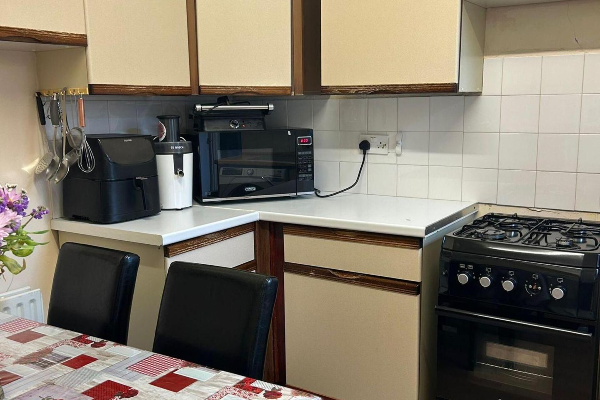 A kitchen with a stove, microwave, and coffee maker.