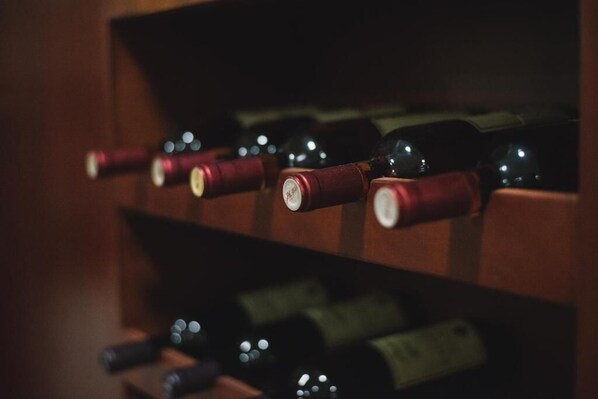 A row of wine bottles with corks in a wooden rack. - Petriti & spa (Ulcinj)