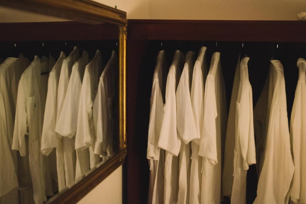 Un armario con camisas blancas colgadas.