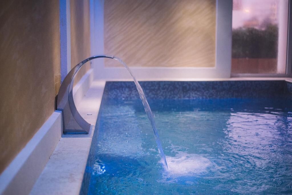 A modern indoor pool with a clear water feature.