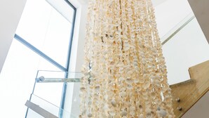 A staircase with a glass railing and a wall decorated with seashells. - Luxury Villa for 10 Guests with Pool and Jacuzzi (Las Terrenas)