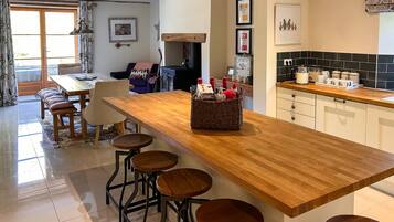 A modern kitchen with a wooden countertop, bar stools, and a built-in stove.