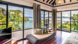 A spacious room with large windows offering a scenic view of a lake and mountains. - TreeHouse Villas - Hilltop Pool Villa (Ko Yao Noi)