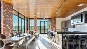 Una cocina moderna con barra, ventanas amplias y un techo alto con vigas de madera.