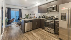 A modern kitchen with stainless steel appliances, dark wooden cabinets, and a central island.