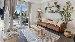 A modern living room with a brown leather sofa, a coffee table, and a ceiling fan.