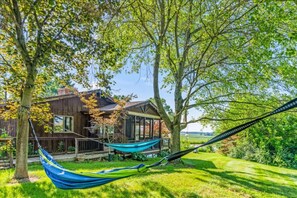 A wooden house with a porch, two hammocks, and a grassy yard. - Secluded 3BR Escape w/ Pool + Pond | Near Columbus (Ashville)