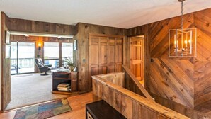 A wooden interior with a staircase, a desk, and a chair.