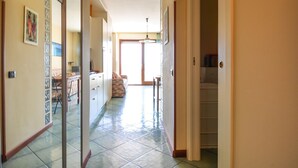 A hallway with a kitchen area, a dining table, and a staircase leading to another level. - Amazing apartment in Alghero with house sea view (Alghero)