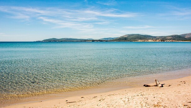 A beach with clear water, a sandy shore, and distant hills. - Amazing apartment in Alghero with house sea view (Alghero)