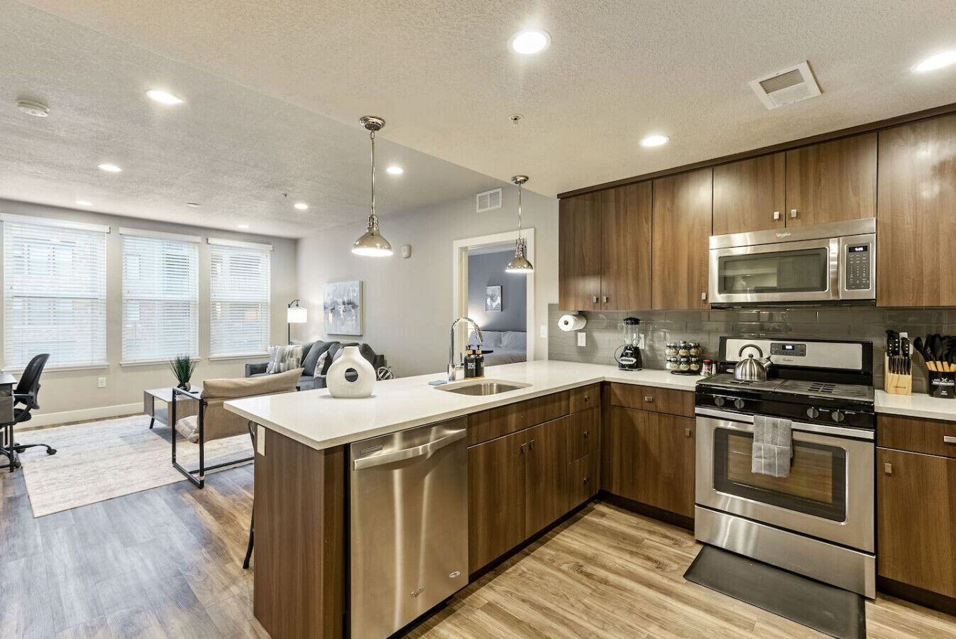 Una cocina moderna con armarios de madera, electrodomésticos de acero inoxidable y una isla central.