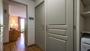 A hallway with a wooden floor, a door with a handle, and a laundry machine. - Apartment for 6 to 8 people in Albiez (Albiez-Montrond)